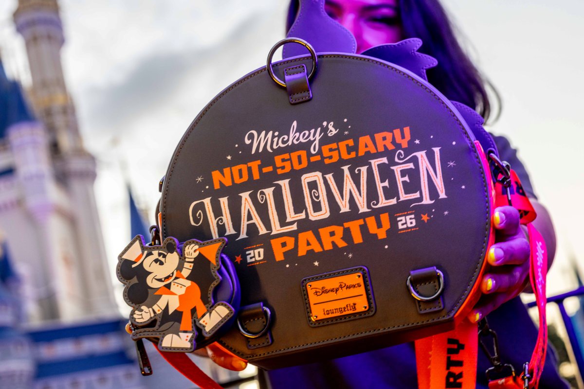 2026 Mickey's Not-So-Scary Halloween Party event bag with the party logo, held in front of Cinderella Castle